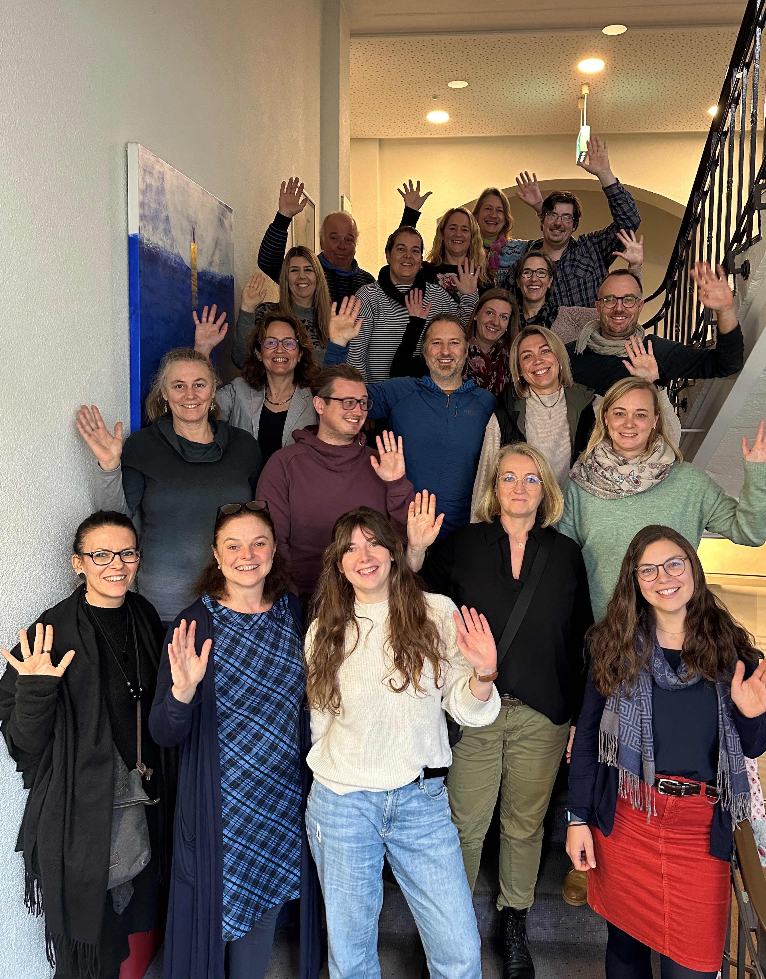 Seminarkollegium winkt auf einer Treppe